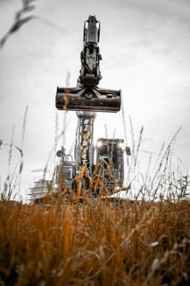 Black Liebherr crawler excavator excavating earth for house construction on building site