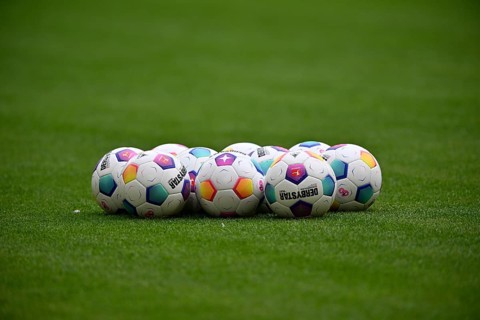 Adidas match balls Derbystar lie on grass