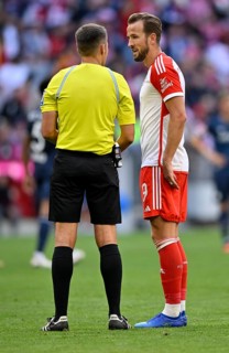 Referee Robert Hartmann in conversation with Harry Kane FC Bayern Munich FCB
