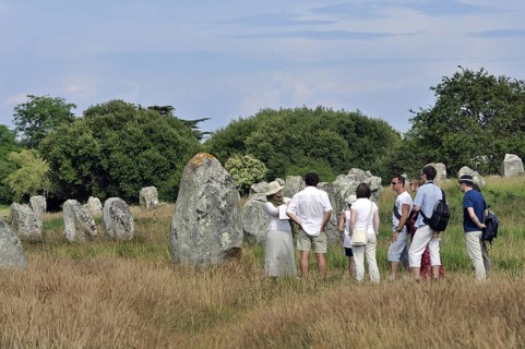 Guide with tourists visiting the Neolithic menhirs