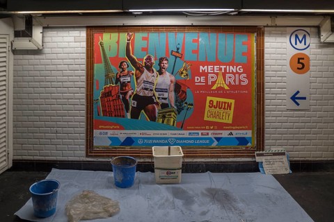 Freshly hoisted large poster in a metro station