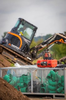 Black Yanmar tracked excavator during earthworks on house construction site