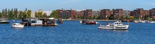 Illegally anchored houseboats in the Rummelsburg Bay with the residential houses on the Rummelsburg shore