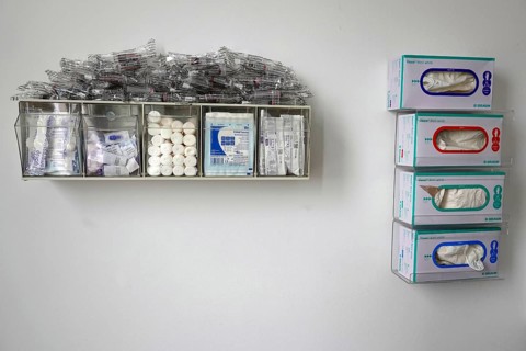 On the wall in a sickroom hangs a box with compartments filled with compresses