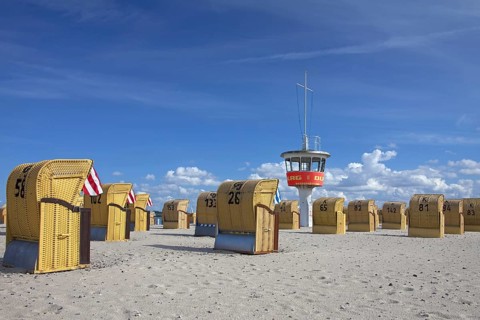 Lifeguard tower and roofed wicker beach chairs on the beach at Travemuende