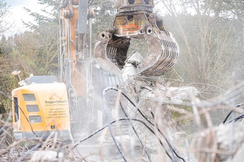 Yellow Liebherr crawler excavator recycling on demolition site