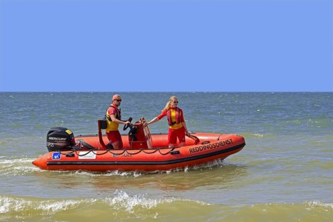 Young Belgian lifeguards in inflatable rescue boat patrolling along the North Sea coast in summer at Koksijde