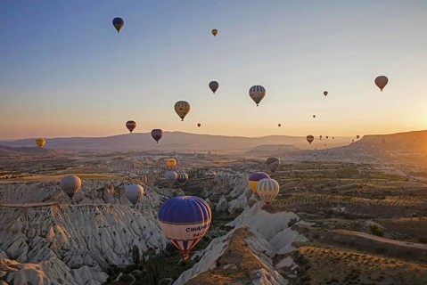 Hot air balloons flying over Cappadocia at sunrise