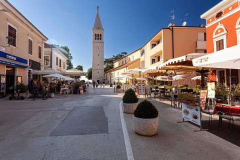 Belltower and terraces of restaurants in the historic town centre of Novigrad
