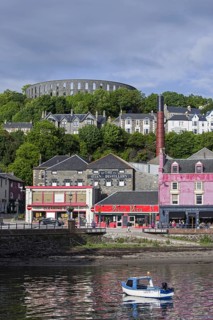 Oban Distillery and McCaig's Tower on Battery Hill overlooking the city Oban