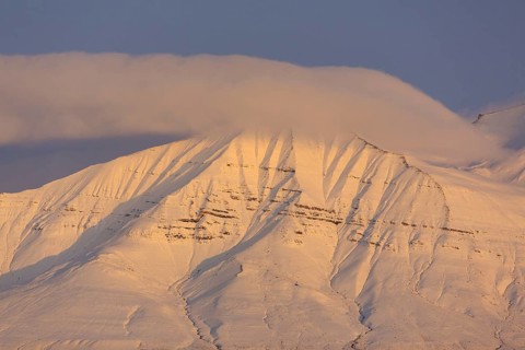 Snow covered mountain peak at sunset at Billefjorden