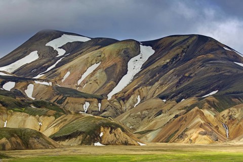 Sulphur coloured rhyolite mountains with patches of snow at Brennisteinsalda volcano near Landmannalaugar