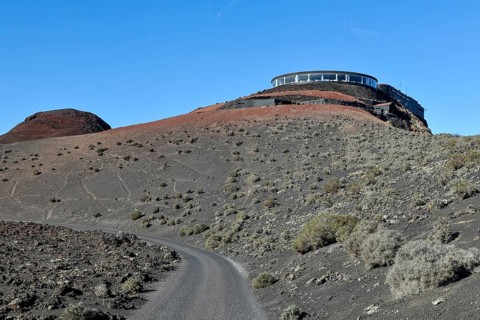 View of volcanic hilltop with tourist centre in Timanfaya National Park with panoramic restaurant El Diablo designed by Cesar Manrique