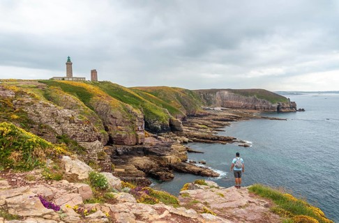 A young tourist on the coast next to the Phare Du Cap Frehel