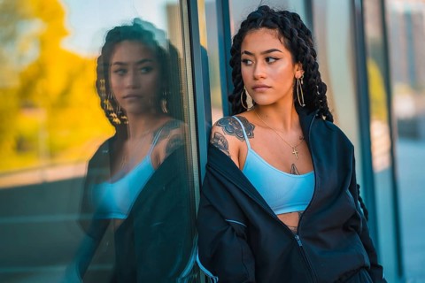 Urban session. Young woman of black ethnicity with long braids and with tattoos