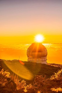 Astronomical Observatory of the Caldera de Taburiente in a beautiful orange sunset with the sun above