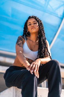 Young woman of black ethnicity with long braids and with tattoos