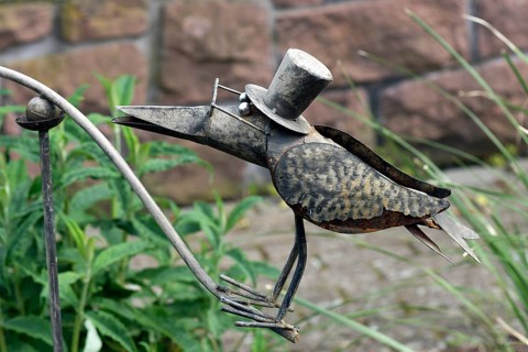Raven as a tin figure in a garden