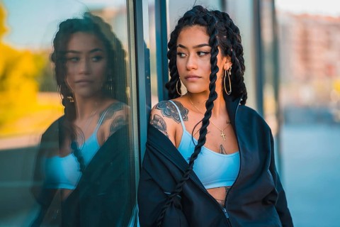 Urban session. Young woman of black ethnicity with long braids and with tattoos