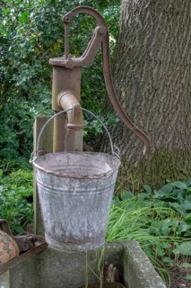 Old Schwengelpumpe and old water bucket made of zinc