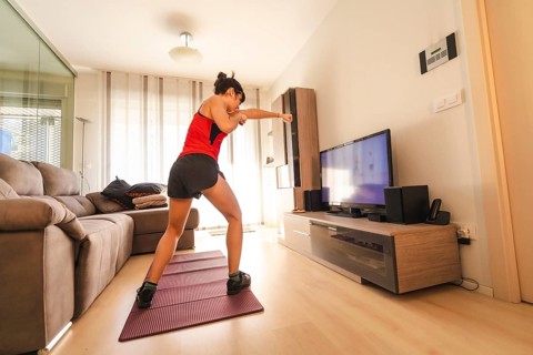 A young woman doing sports in her living room. Sport in the quarantine at home