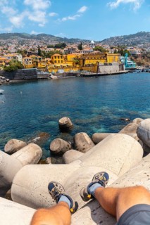 Sitting looking at yellow fort by the sea from Forte de Sao Tiago on Funchal beach. Madeira