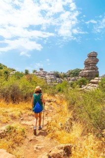 A young woman trekking in Torcal de Antequera on the green and yellow trail