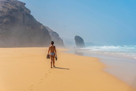 A young woman in the Roque del Moro of the Cofete beach of the natural park of Jandia