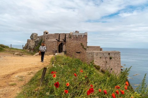 A young tourist visiting Castle Fort-la-Latte by the sea at Cape Frehel and near Saint-Malo