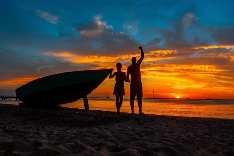 A couple watching the Roatan Sunset from West End. Honduras