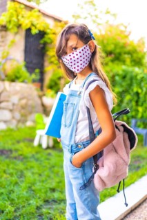 Caucasian girl with face mask ready to go back to school. New normality