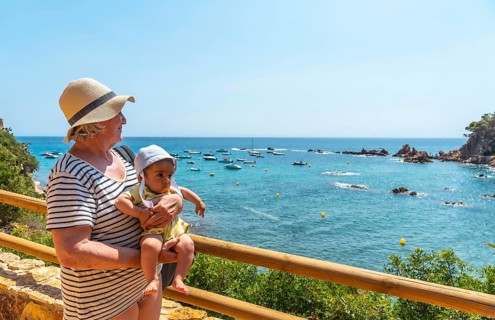 A grandmother and grandson having fun in the summer in Cala Canyet next to the town of Tossa de Mar. Girona