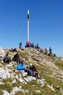 Many hikers at the summit of the Benediktenwand