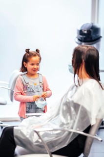 Client sitting waiting for the dye to dry and meanwhile talking to her daughter. Reopening with security measures for hairdressers in the Covid-19 pandemic