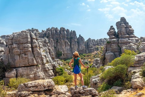 A young woman in Torcal de Antequera on the green and yellow trail enjoying freedom