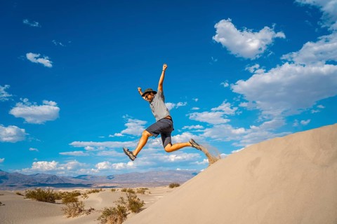 A young man jumping in desert on a summer afternoon in Death Valley