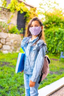 Caucasian girl with face mask ready to go back to school. New normality