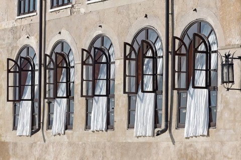 Window front with white curtains in historical building