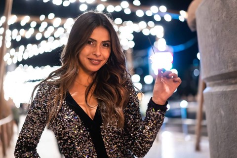 Winter lifestyle at Christmas. Brunette Caucasian girl in a fashionable dress with sequins