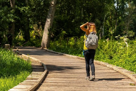 A young woman trekking on the footpath along a footbridge between La Garette and Coulon