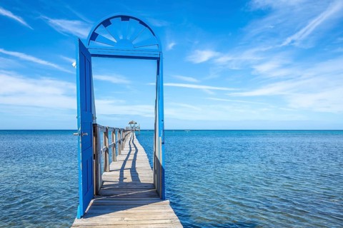 A blue door on the beach of Sandy Bay on the Roatan Island of the Caribbean Sea. Honduras
