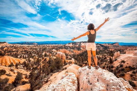 A girl with her arms outstretched enjoying the views from the Sunrise Point in Bryce National Park. Utah
