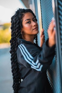 Urban session. Young black ethnic woman with long braids and with tattoos