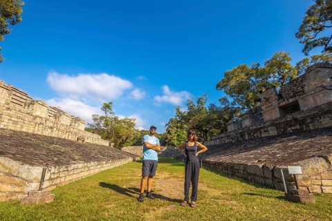 A couple strolling through the ball game in the temples of Copan Ruinas. Honduras