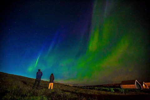A couple in Northern lights in the sky on the Reykjanes peninsula in southern Iceland