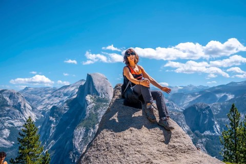 A young woman in pink and black at the Glacier point on the Half Dome wall. Yosemite National Park
