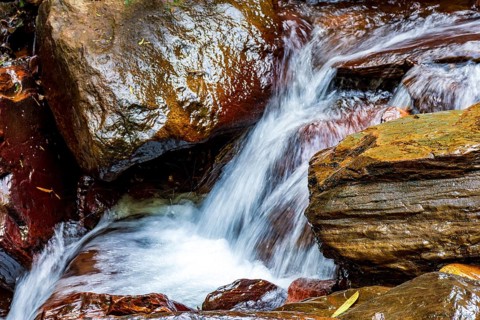 Movement of river water flowing between rocks in the rainforest in Minas Gerais