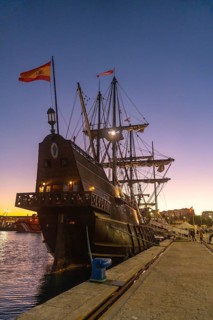 Old boat at sunset on the promenade of Muelle Uno in the Malagaport of the city of Malaga