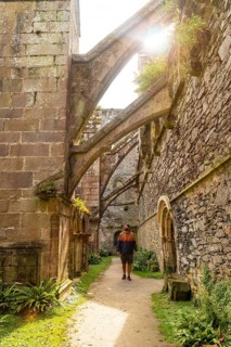 A young man visiting the interior gardens of the Abbaye de Beauport in the village of Paimpol