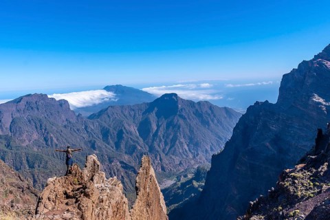 A young man after finishing the trek at the top of the volcano of Caldera de Taburiente near Roque de los Muchachos looking at the incredible landscape